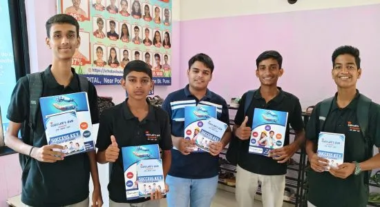 Students holding MHT CET Exam Brochure.